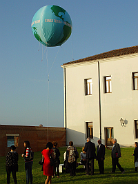 Besucher lesen die Inschrift azf der Bank unter dem Ballon